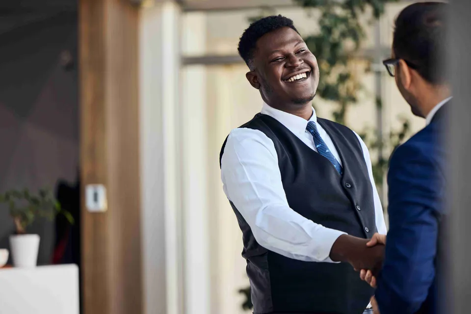 Smiling professionals shaking hands in a modern office