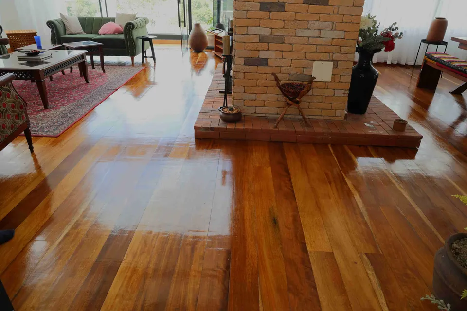 Living room with a glossy hardwood floor and a brick fireplace